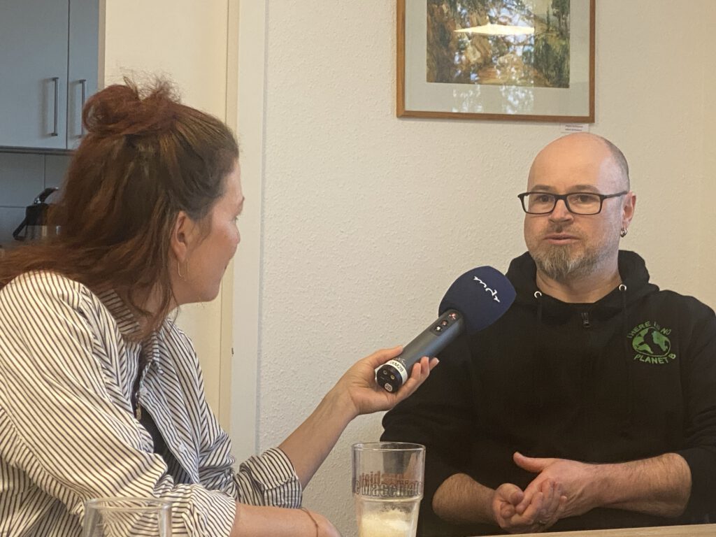 links im Bild eine Frau, die ein Mikrofon vom MDR in der Hand h&auml;lt. Ihr gegen&uuml;ber sitzt ein Mann und spricht in das Mikrofon